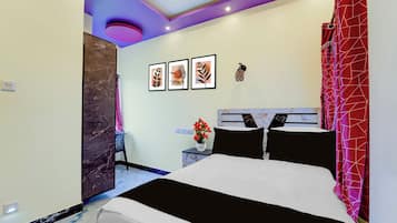 Un dormitorio moderno con una cama, una mesita de noche, un florero con flores y decoración en la pared.