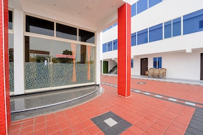 A modern building with a reception area, a staircase, and a seating area with a bench.