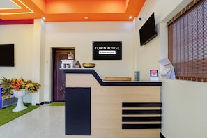 A reception desk with a sign indicating it's serviced by YOO. - Townhouse Kanyakumari Bus Terminal (Nagercoil)