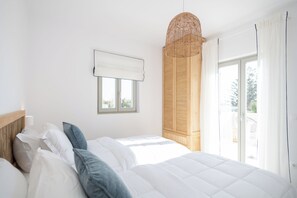 Ein Schlafzimmer mit Bett, einem Fenster mit Blick und einer Wandleuchte.