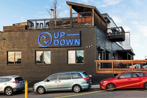 Ein Gebäude mit einem Schild, auf dem 'UP DOWN' steht, und ein Parkplatz mit Autos.