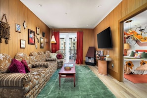 Ein Wohnzimmer mit einer Couch, einem Couchtisch, einem Kamin und einem Fernseher.