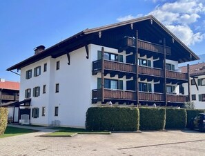 A multi-story building with balconies, a flat roof, and a paved driveway. - Vacation rental with a terrace, living room/bedroom, 32 m² (Inzell)