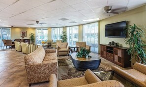 A spacious lobby with a large sofa, armchairs, a coffee table, and a television mounted on the wall. - 3X3BR Desert Escape Near Coachella & amenities (Palm Springs)