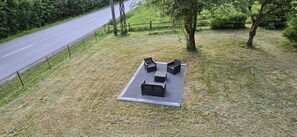 An outdoor seating area with a table and chairs, surrounded by grass and trees. - Spacious vacation home (sleeps 10) near Gérardmer—ideal for groups and pets (Granges-Aumontzey)