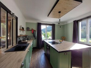 A kitchen with a wooden countertop, a sink, and a window with curtains. - Spacious vacation home (sleeps 10) near Gérardmer—ideal for groups and pets (Granges-Aumontzey)