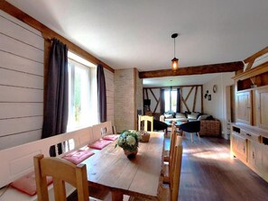 A cozy dining area with a wooden table, chairs, and a potted plant. - Spacious vacation home (sleeps 10) near Gérardmer – ideal for groups and pets (Granges-Aumontzey)