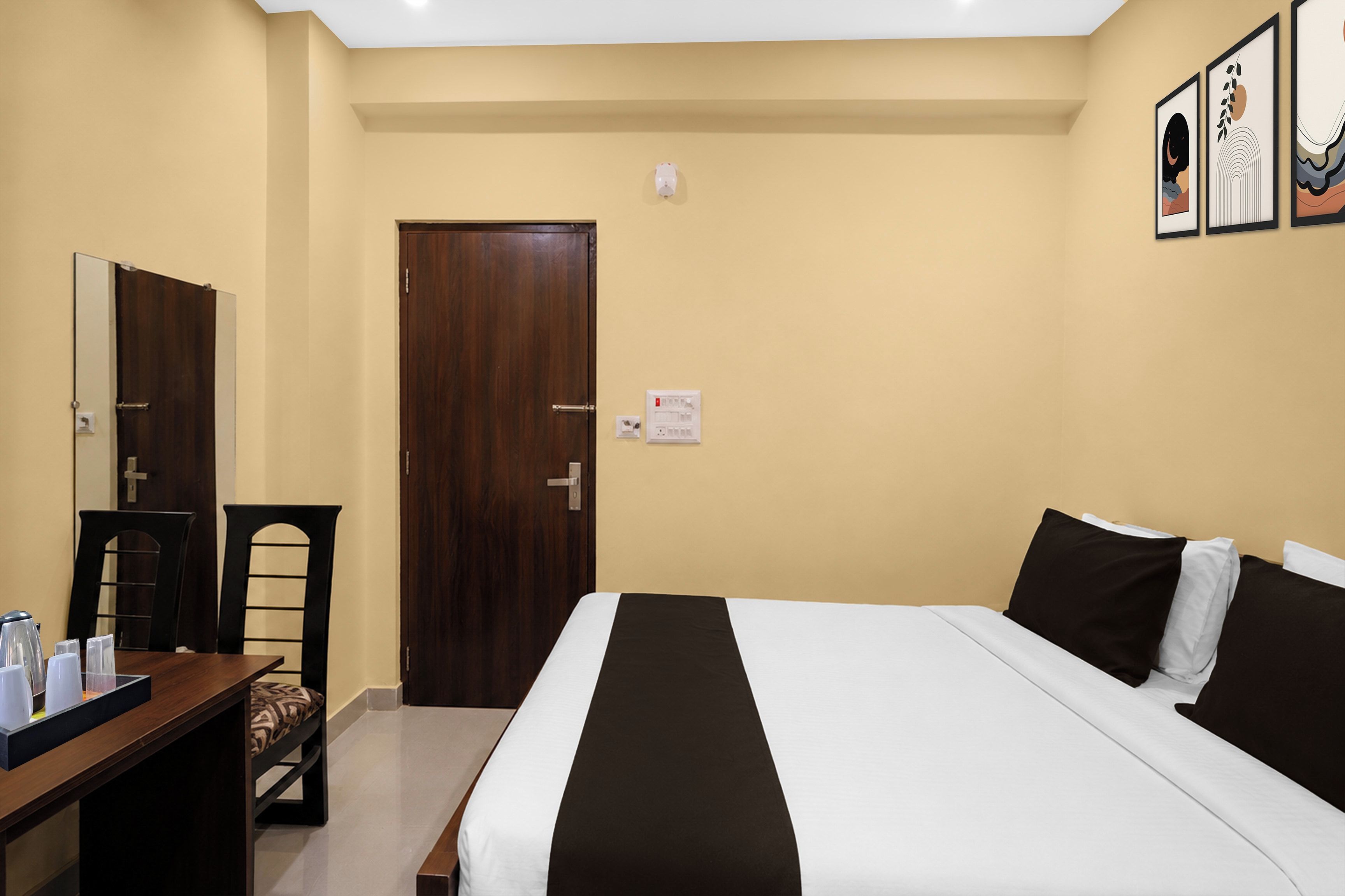 Una habitación de hotel con cama, escritorio, silla, armario y puerta.
