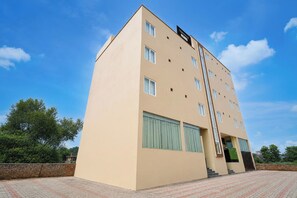 A multi-story building with a flat facade, large windows, and a sign indicating it is a 'Townhouse.' - Townhouse GT Road Dadri (Dadri)