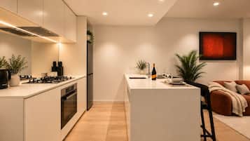 A modern kitchen with a central island, built-in appliances, and a dining area with a sofa and table.