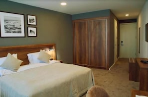 A hotel room with a bed, a wardrobe, and a desk. - Yacht Club (Baku)