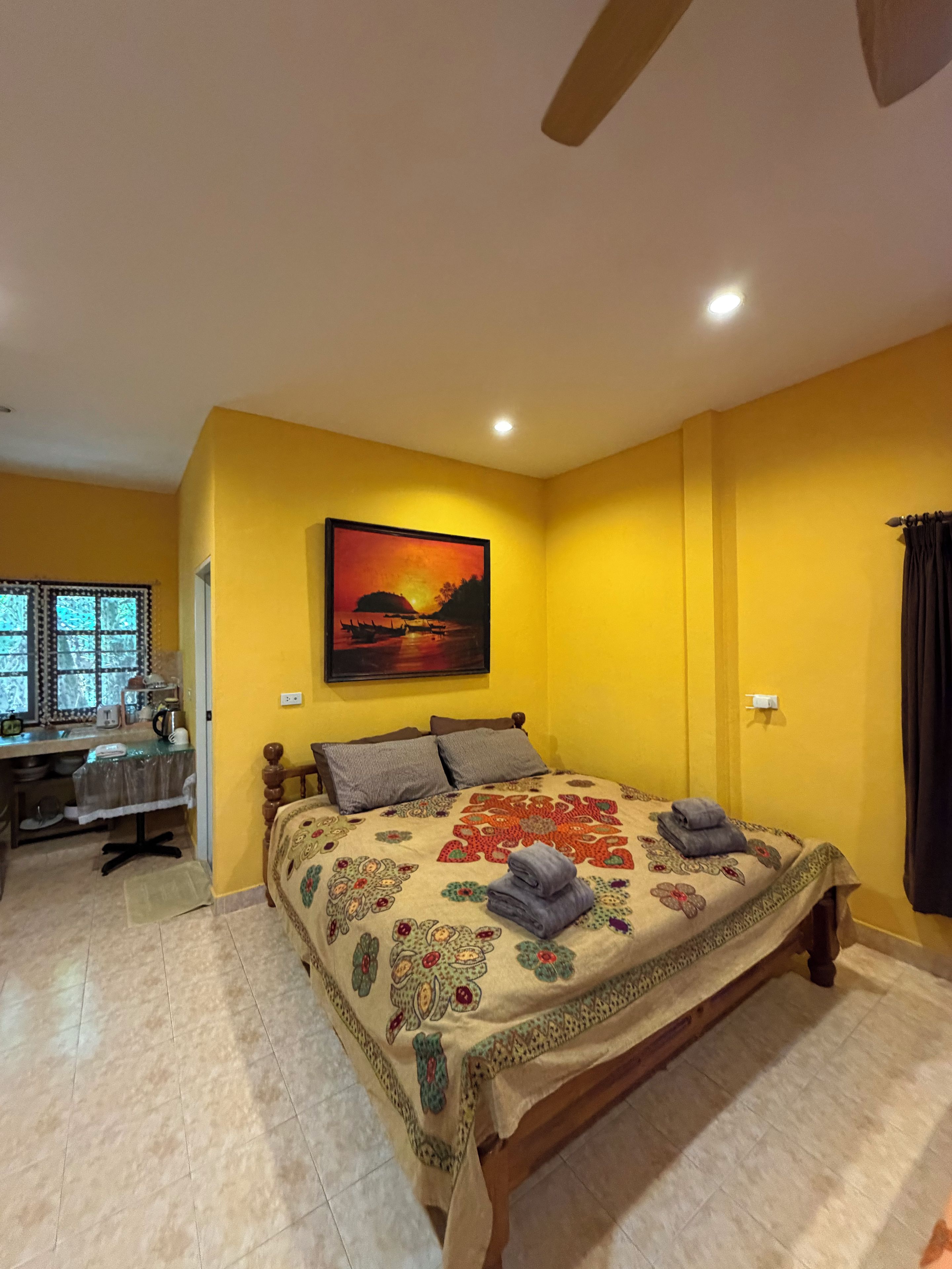 Un dormitorio con una cama, un escritorio y un cuadro en la pared.