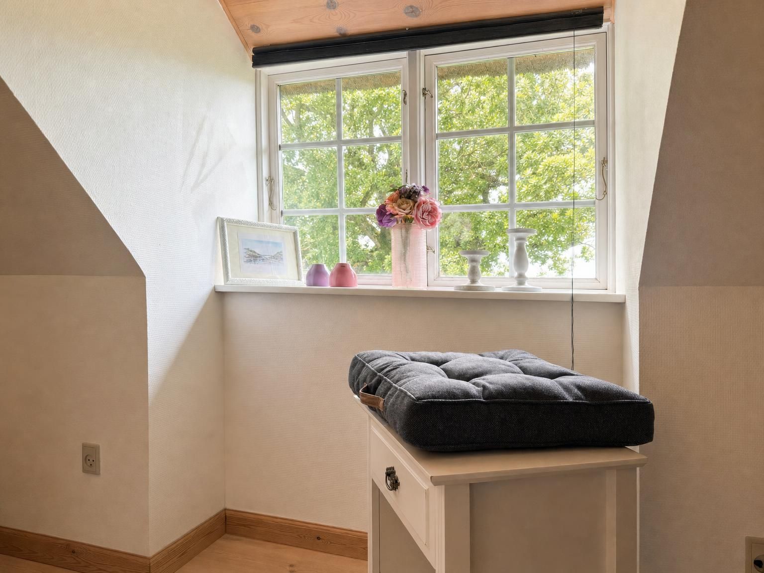 A room with a window, a bedside table, and a bed.
