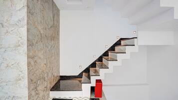 Una escalera moderna con una pared de mármol en un lado y un suelo estampado.
