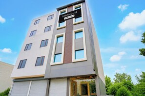 A multi-story building with a sign indicating it is serviced by OYO.