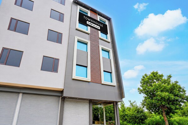 A multi-story building with a sign indicating it is serviced by OYO.