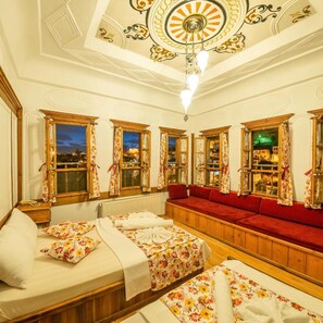 A hotel room with a large window, a sofa, and a bed. - Cesmeli Konak (Safranbolu)