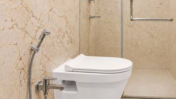 Een moderne badkamer met toilet, douche en douchecabinedeur.