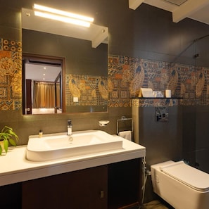 Un baño moderno con un espejo grande, un lavabo, un inodoro y una ducha.