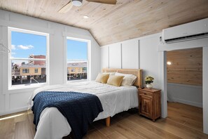 Ein Schlafzimmer mit einem großen Bett, einem hölzernen Kopfteil und einem Nachttisch mit einer Vase.
