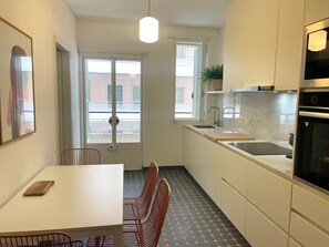 Eine kompakte Küche mit Essbereich, einem Fenster mit Aussicht und modernem Design.