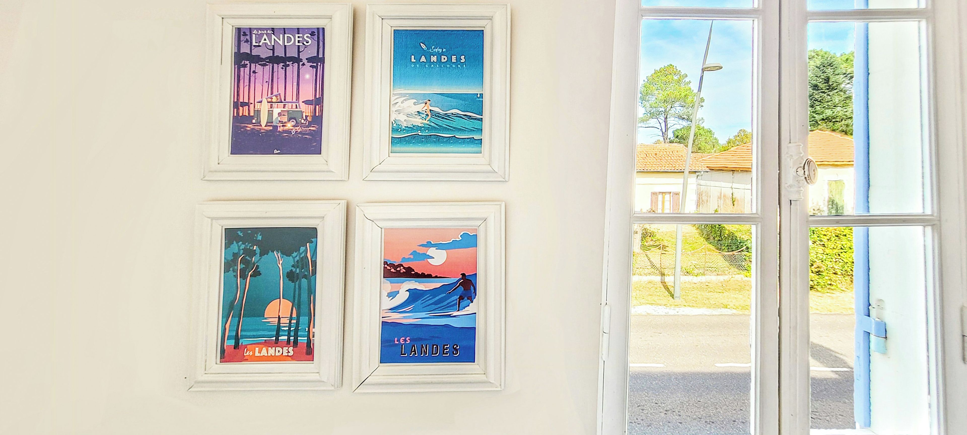 Four framed posters on a wall, each depicting different landscapes.