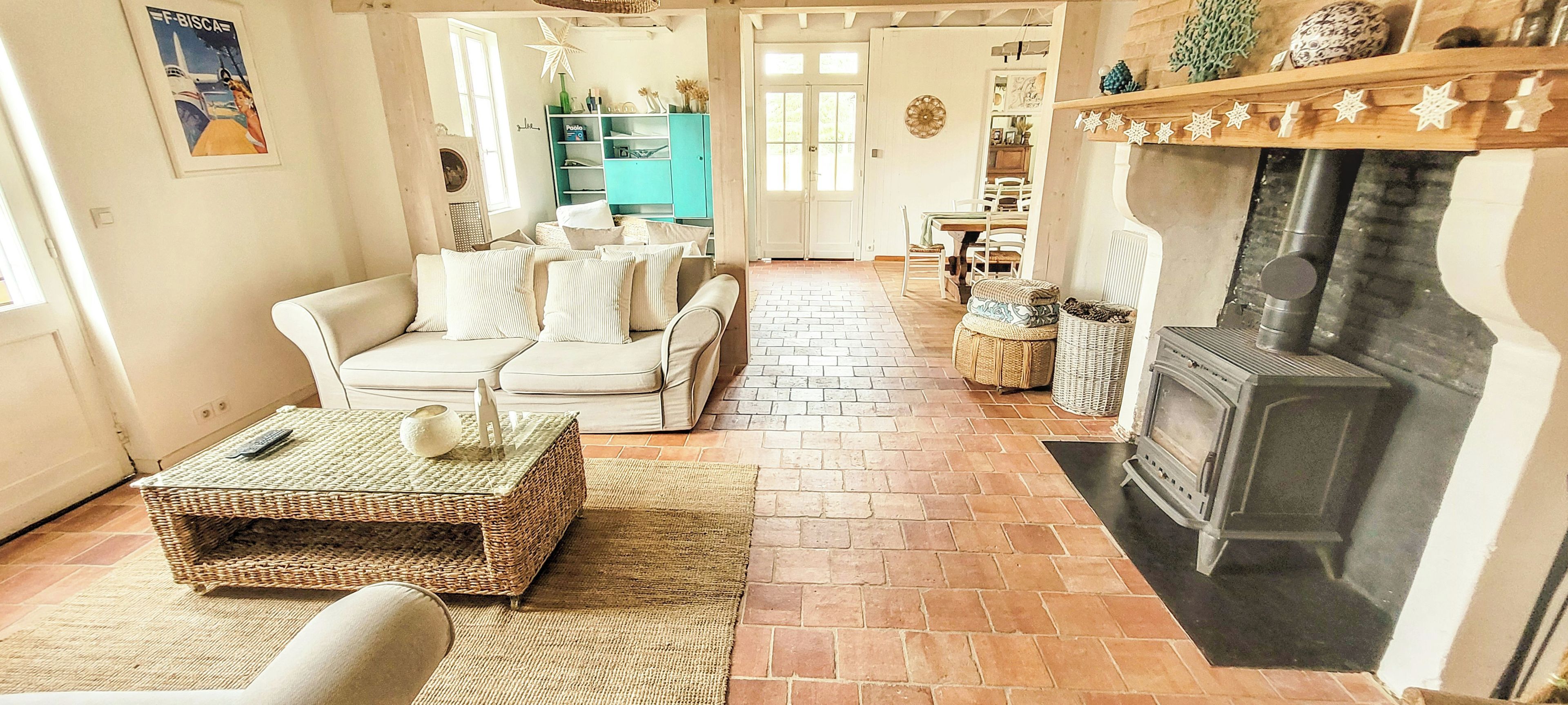 A cozy living room with a fireplace, a sofa set, and a wicker coffee table.