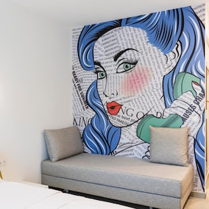 A wall with a graphic design featuring a stylized face and text. - Motivo Thassos (Thasos)