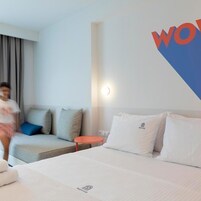 Una habitación de hotel con una cama, un sofá y una mesita de noche.