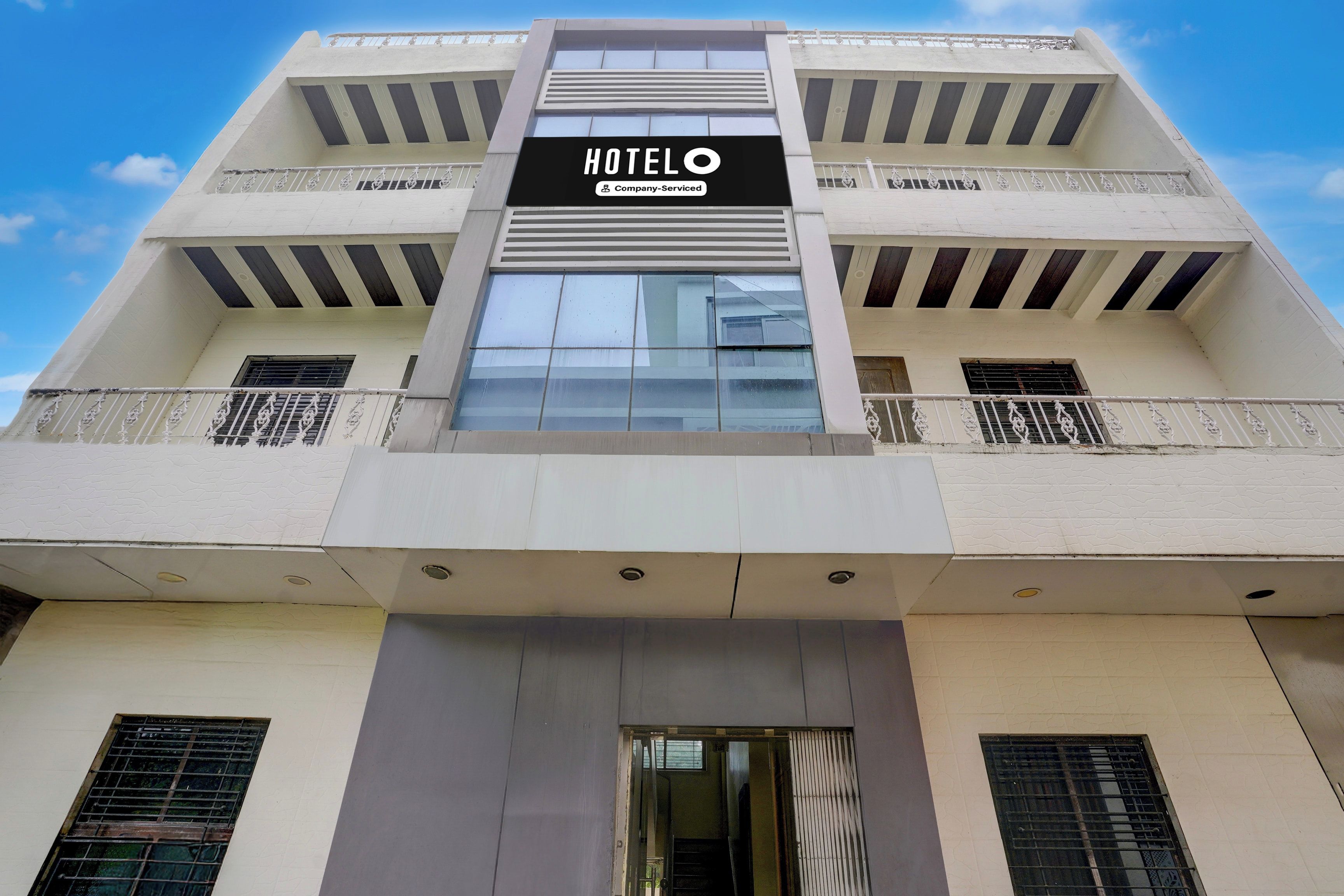 A hotel building with a sign reading 'HOTELO Company Serviced'.