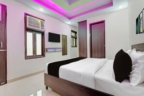 A modern bedroom with a bed, wardrobe, and a flat-screen TV mounted on the wall. - Collection O Palam Metro Station (New Delhi)