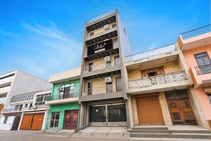 Un edificio de varios pisos con un cartel que indica que cuenta con servicios de OYO.