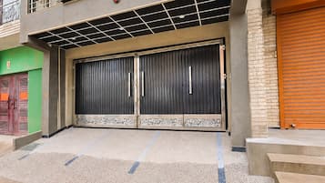 Um edifício com uma grande porta dupla escura, com desenhos decorativos na parte inferior.
