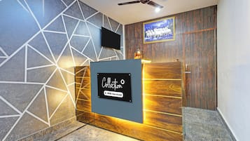 A reception desk with a sign indicating it is serviced by OYO.