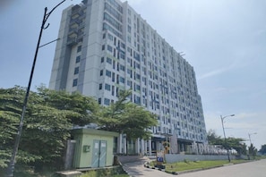 A multi-story building with a modern architectural design, featuring a uniform facade and a series of balconies. - Izi Cozi Jababeka Enviro (Cikarang)