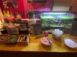 A food display with various items including jars, a chalkboard menu, and a fish tank.