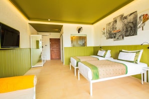 A hotel room with two beds, a television, and artwork on the wall. - Amba Yaalu Kandalama (Kandalama)