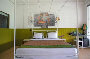 Een hotelkamer met een bed, nachtkastje, lamp en kunstwerk aan de muur.