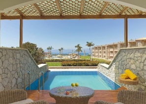 A pool area with a view of a building and mountains in the background.