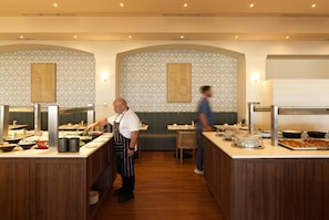 A restaurant with a central island and seating on either side.