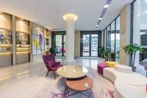 A modern lobby with a reception desk, seating area, and large windows. - Lavande Hotel (Guilin)