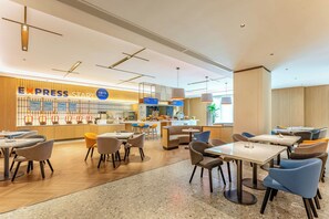 Un hall d’hôtel moderne comprenant un espace de réception, des coins salon et un comptoir bien visible sur lequel est affiché un panneau indiquant « EXPRESS START ».
