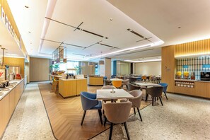 A modern dining area with a central bar, multiple seating options, and a kitchen visible in the background. - Holiday Inn Express Wuxi East Station (Wuxi)