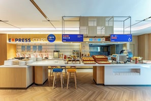 A modern hotel lobby with a reception desk, seating area, and a buffet counter. - Holiday Inn Express Wuxi East Station (Wuxi)