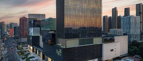 Een modern hotelgebouw met een opvallend 'INTERCONTINENTAL' bord, omgeven door een drukke stadsstraat en andere hoogbouw.