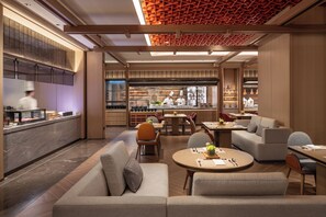 A modern restaurant interior with a chef preparing food, seating arrangements, and a kitchen area. - Intercontinental Zhengzhou (Zhengzhou)