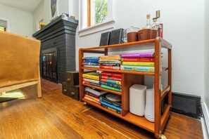 Une bibliothèque contenant divers ouvrages et deux haut-parleurs blancs.