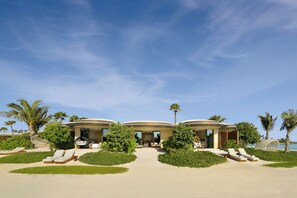 Un resort con piscina, tumbonas y palmeras.