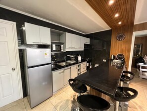 Eine moderne Küche mit einer zentralen Kochinsel, integrierten Geräten und einer Holzbeschichtung an der Decke.
