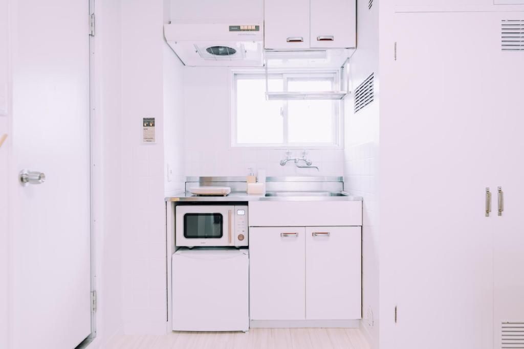 A white kitchen with a microwave, oven, and cabinets.